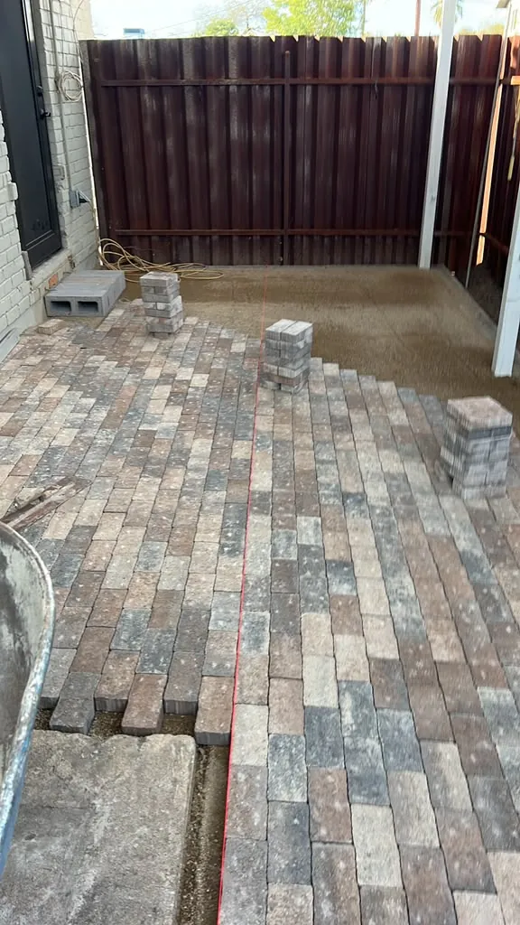 Finished paver patio in multi-tone brick, laid tight against the block wall
